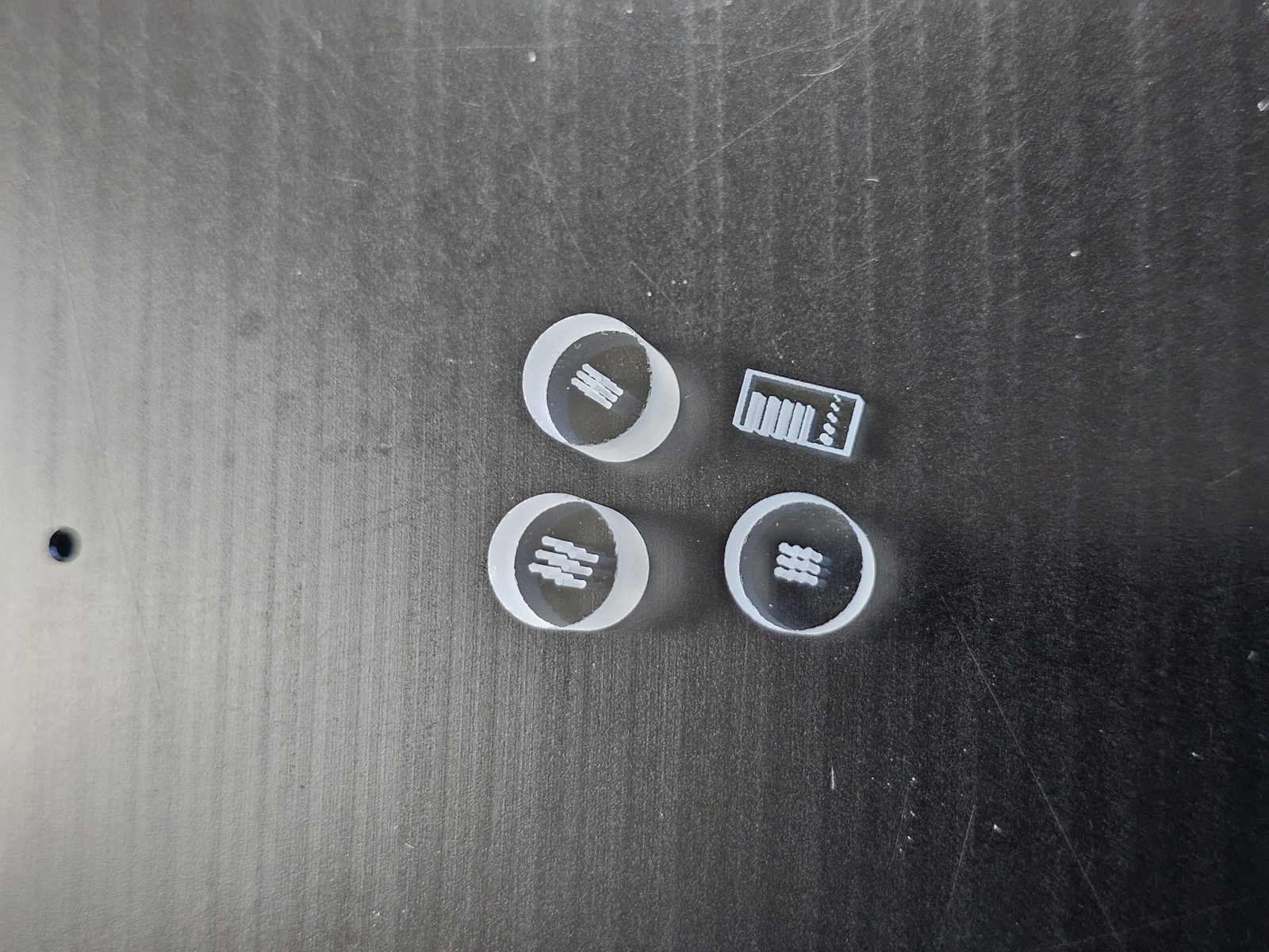 Micro glass parts with hole arrays and slots — size comparison